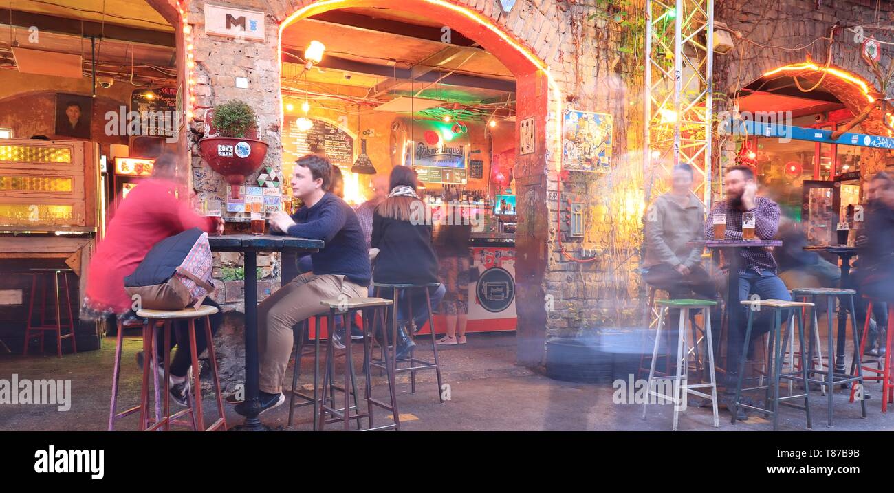 BUDAPEST, HUNGARY - april 2019: Interior view of the famous Szimpla Garden ruin pub with people sitting at table enjoying night life. Stock Photo