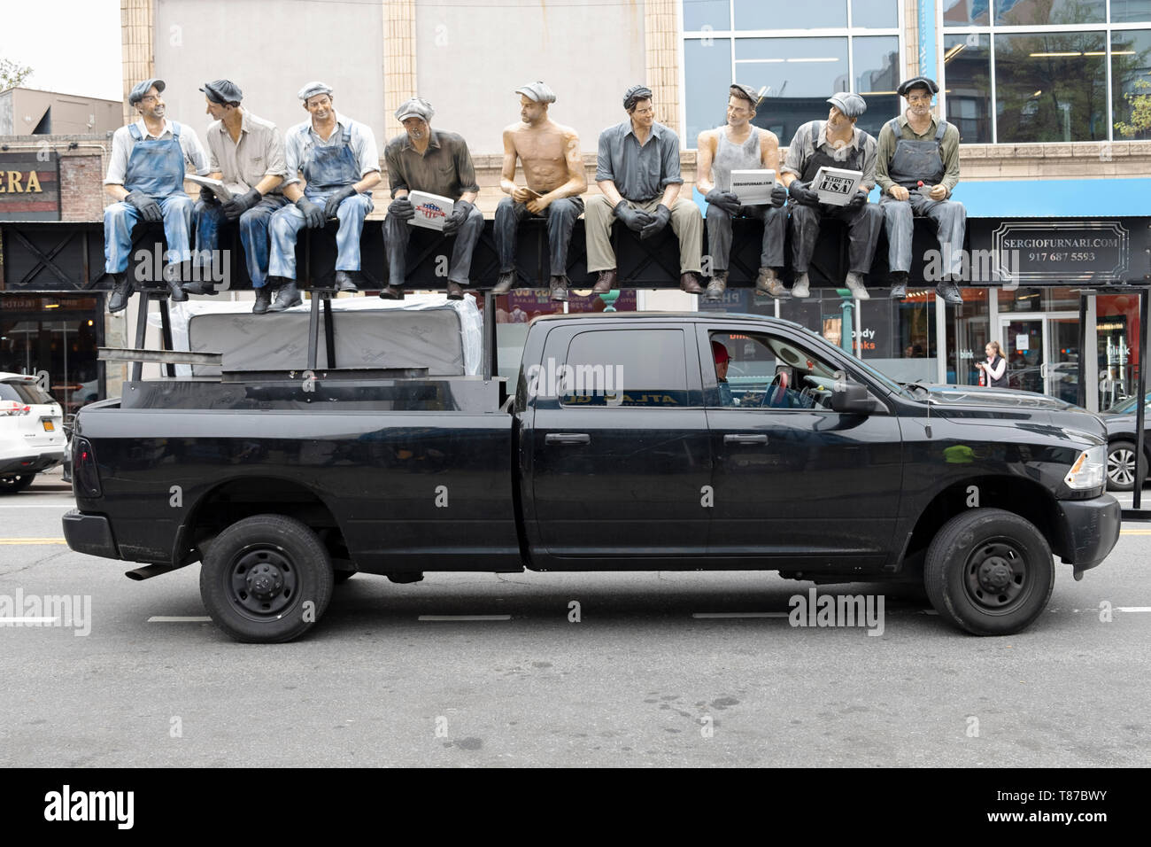 A delivery truck with a reproduction of the famous photo of construction workers eating lunch atop a skyscraper. In Astoria, Queens, New York. Stock Photo