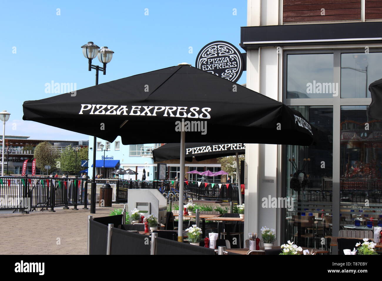 10 May 2019: Cardiff Bay, Cardiff UK:  Pizza Express in Cardiff Bay in the sunlight, waiting for the lunch hour rush.  Al fresco dining springtime. Stock Photo