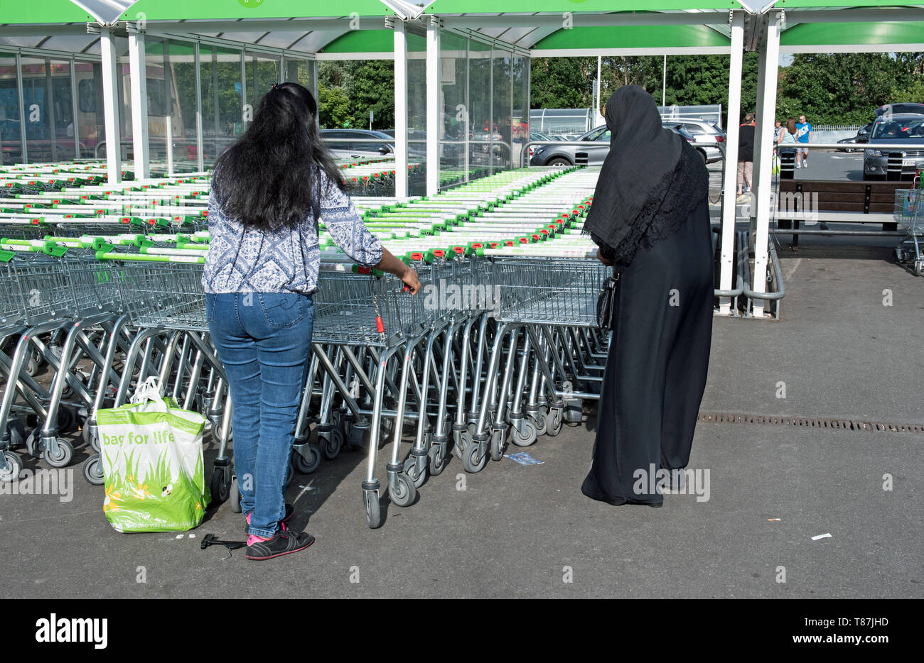 Two ladies with supermarket trolleys, ASDA Crossharbour, London Borough of Tower Hamlets. Stock Photo