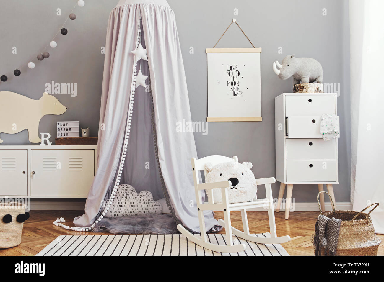 Stylish and modern scandinavian nursery interior with gray walls, brown