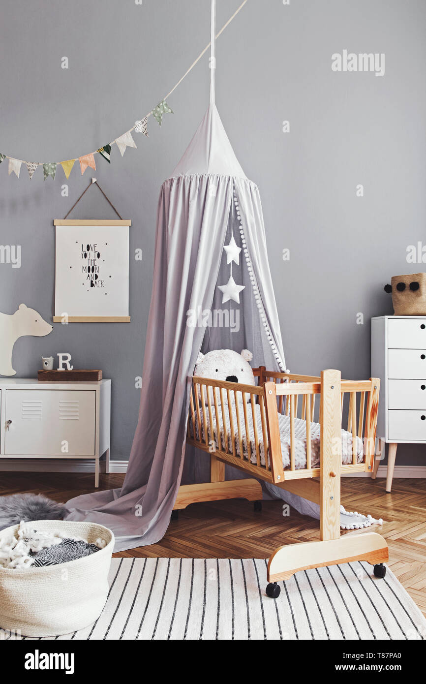 Stylish and modern scandinavian nursery interior with gray walls, brown