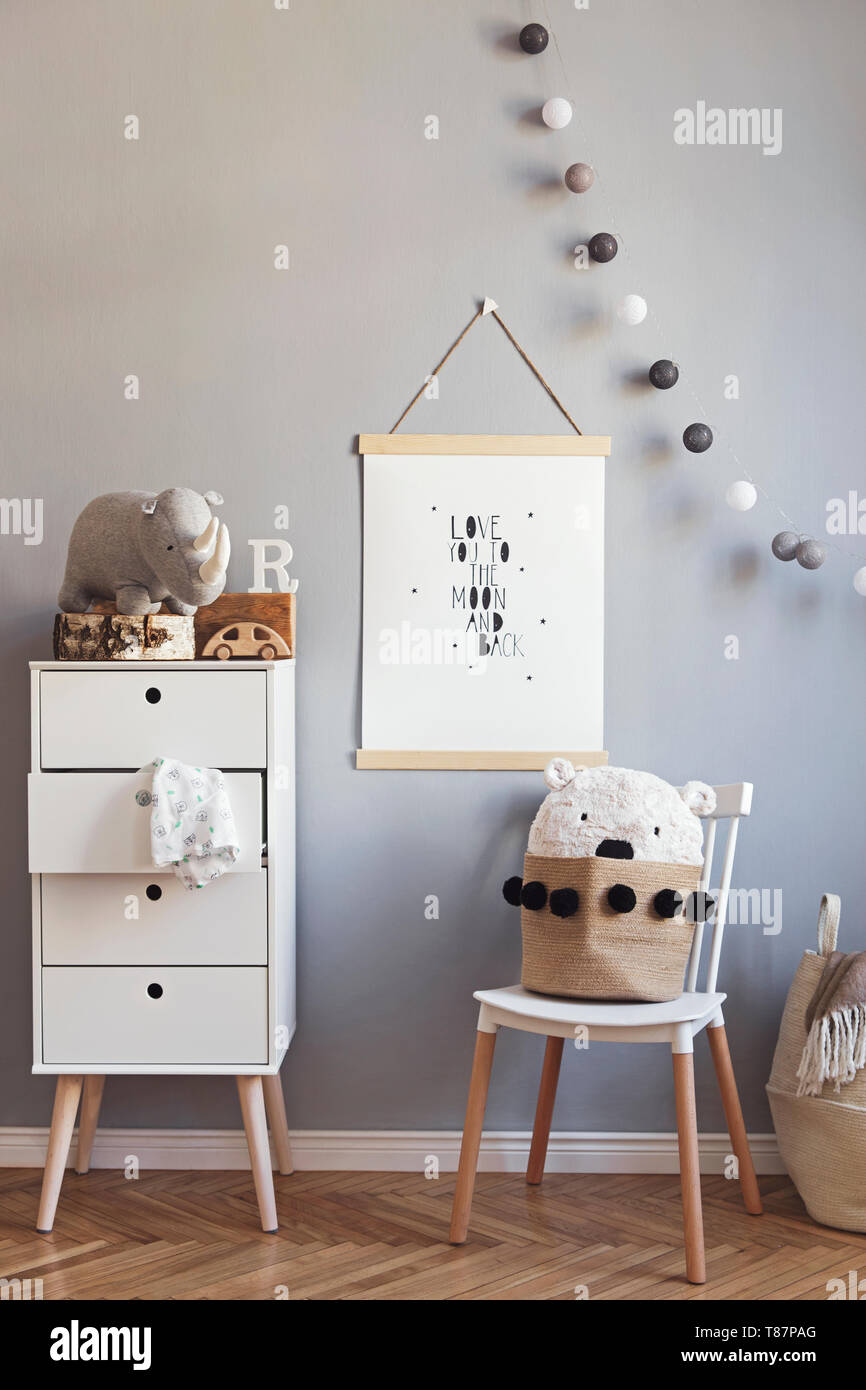Stylish and modern scandinavian nursery interior with gray walls, brown