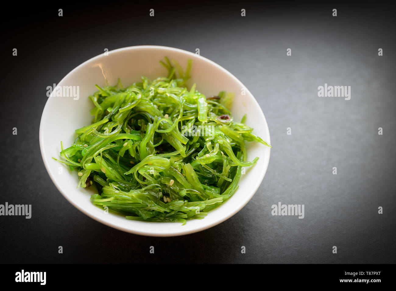 Wakame salad or seaweed salad on dark background. Selective focus. Stock Photo