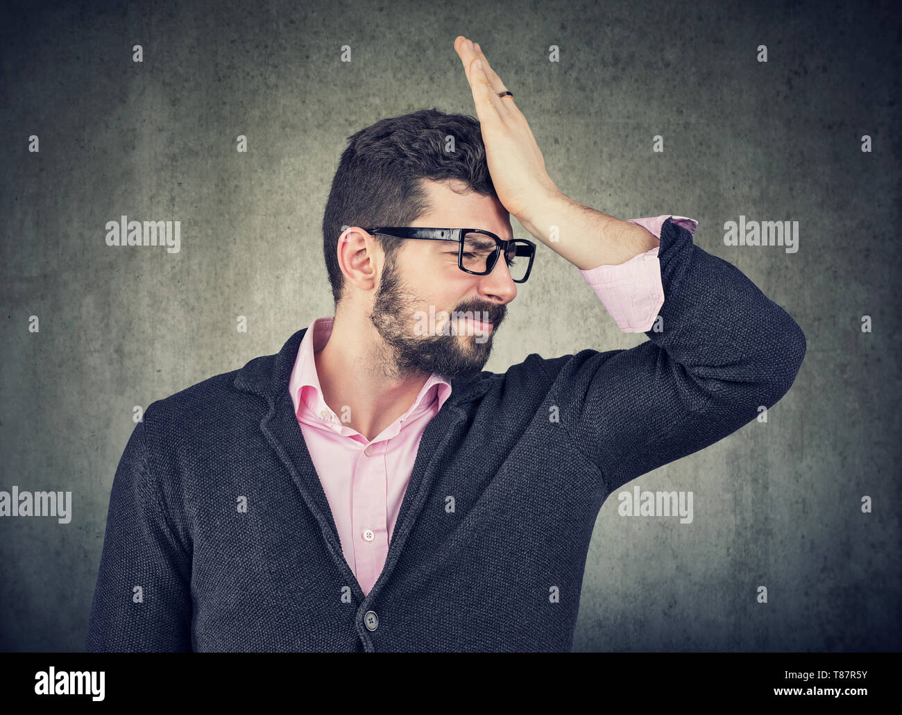 Regrets and wrong doing. Portrait of a stressed anxious young man, slapping hand on head realizing mistake. Stock Photo