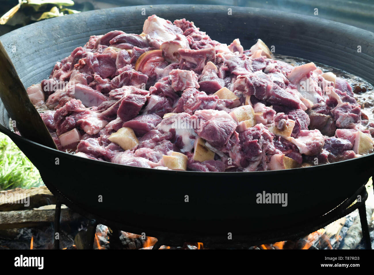 https://c8.alamy.com/comp/T87RD3/small-sliced-meat-cooked-on-a-a-very-big-pan-using-fire-wood-raw-meat-T87RD3.jpg