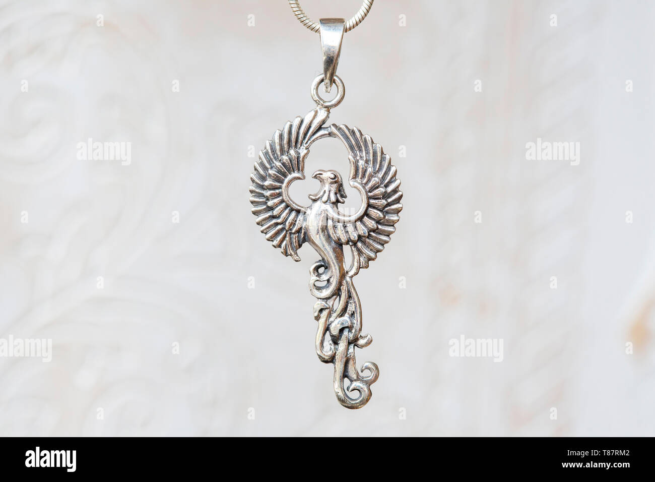 silver phoenix bird pendant on natural white background T87RM2