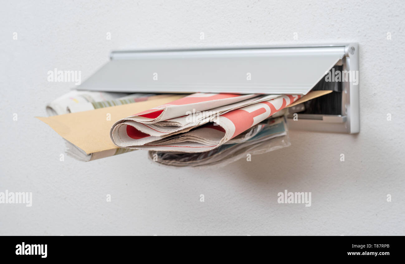 A letter and newspapers in a letterbox Stock Photo Alamy