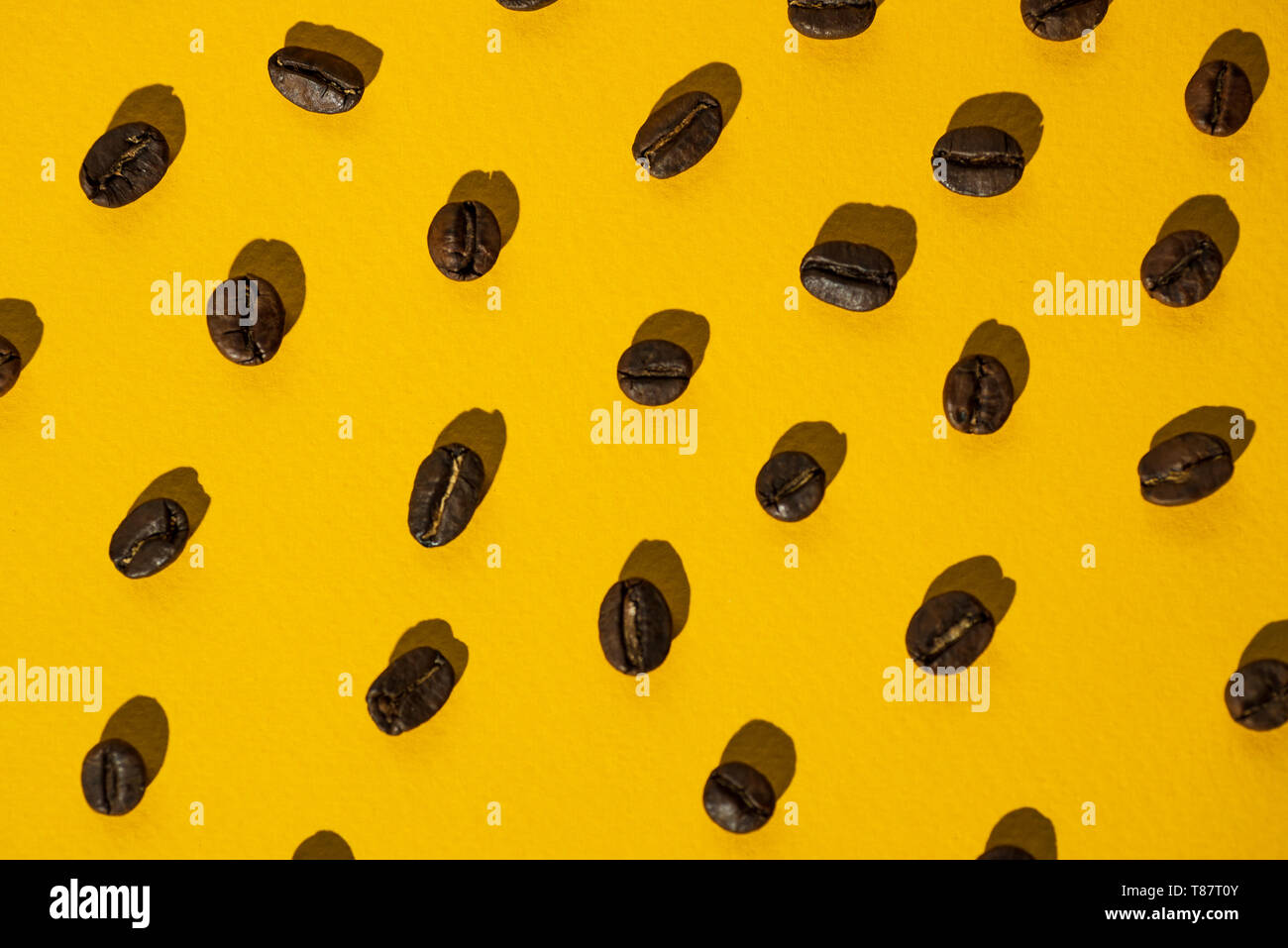 the pattern of coffee beans on bright colored background Stock Photo