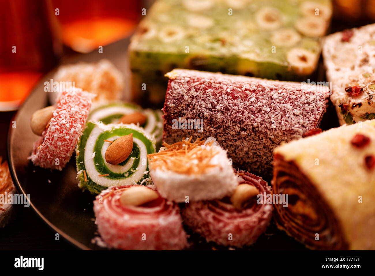 Close up of various turkish delights with nuts and tea glasses Stock Photo