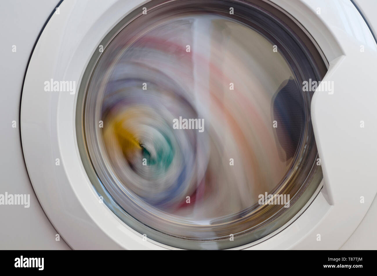 Washing machine door with rotating garments inside Stock Photo Alamy