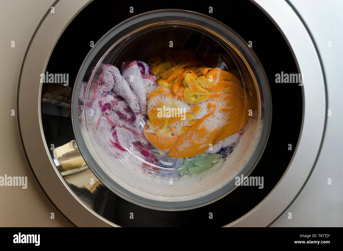 Washing machine door with rotating garments inside Stock Photo Alamy
