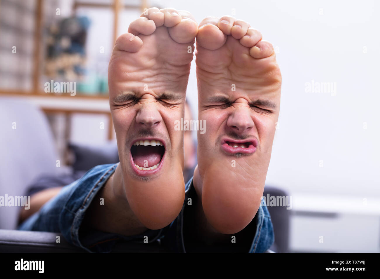 Close-up Of Man's Feet With Painful Facial Expression Stock Photo