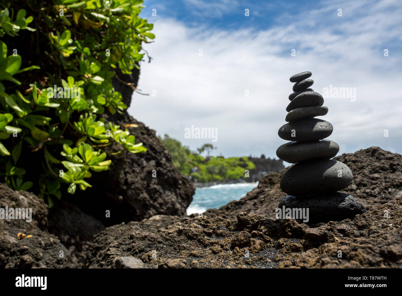 A stack of rocks on black sand beach, Maui, Hawaii Stock Photo