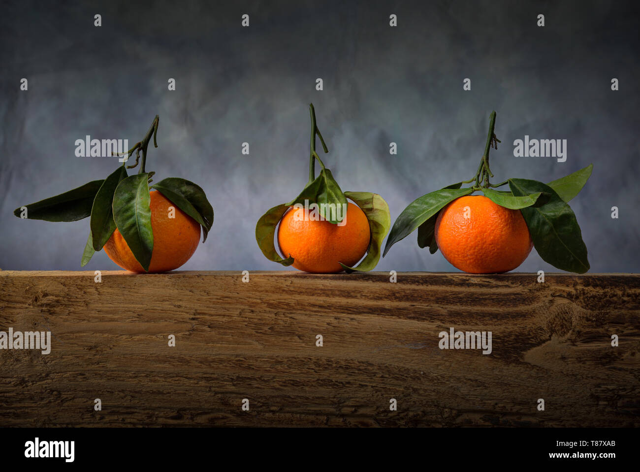 Three satsumas with leaves Stock Photo Alamy