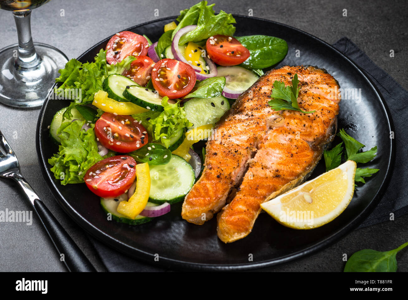 Grilled salmon fish steak with vegetables on black Stock Photo - Alamy