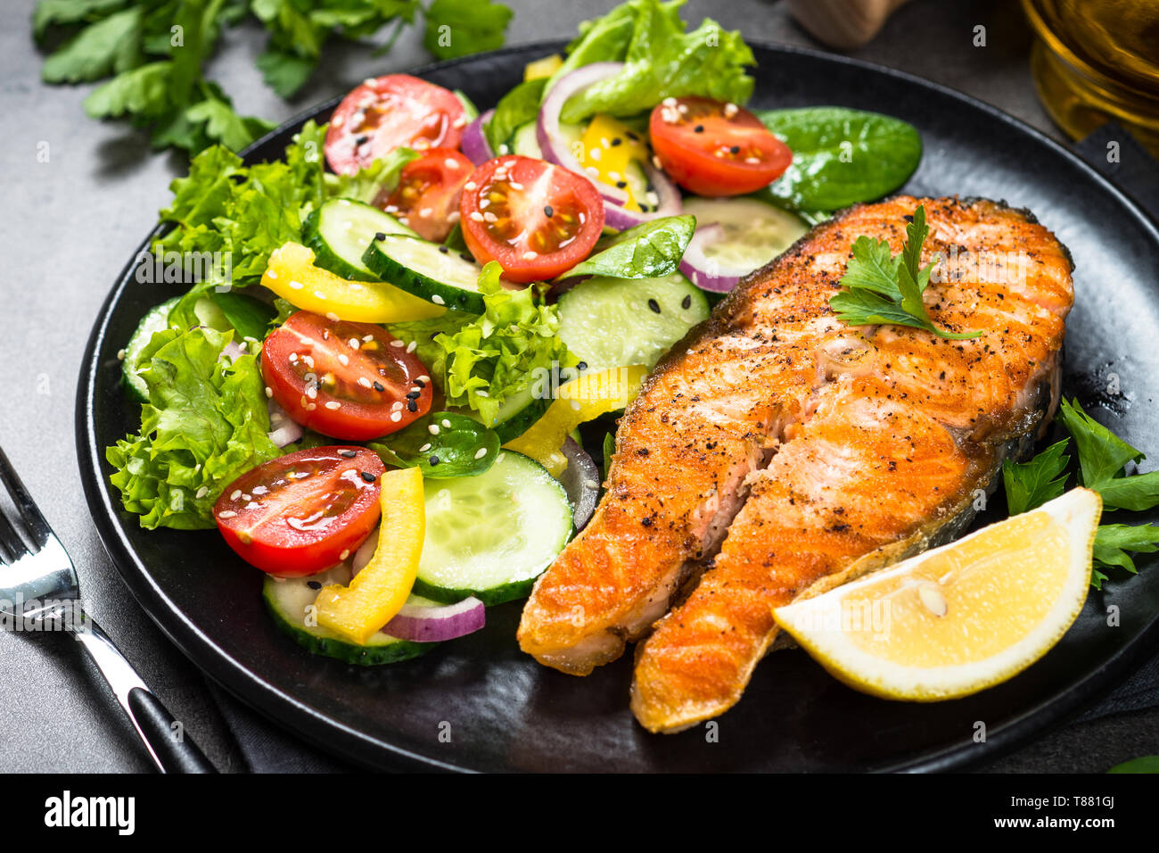 Grilled salmon fish steak with vegetables on black Stock Photo - Alamy