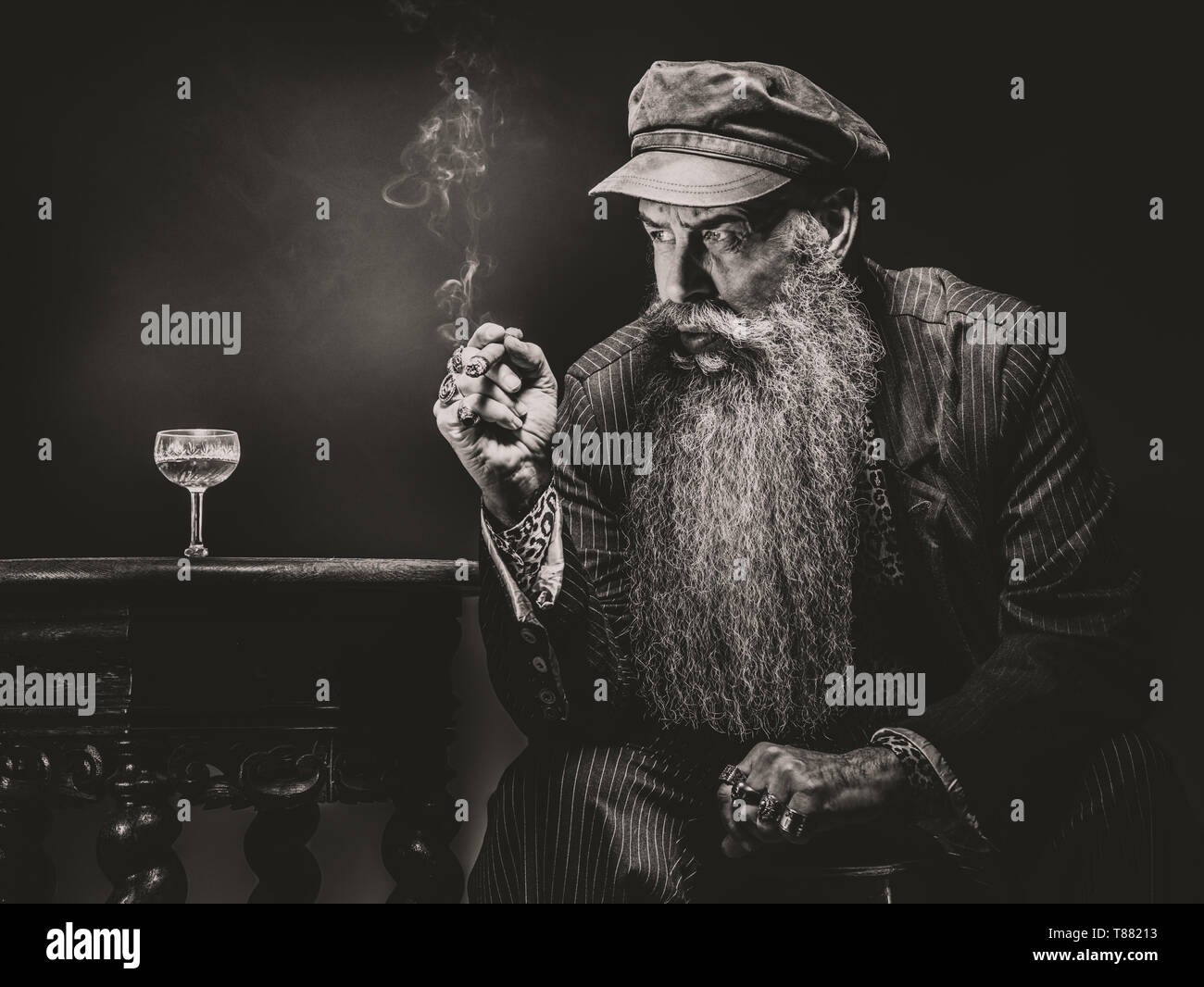 man sitting at the table with long beard and smok Stock Photo
