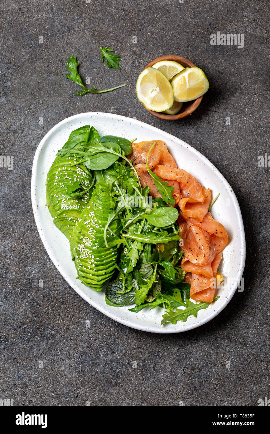 Low carbs salad. Spinach, rucola salad with avocado and salmon. Black