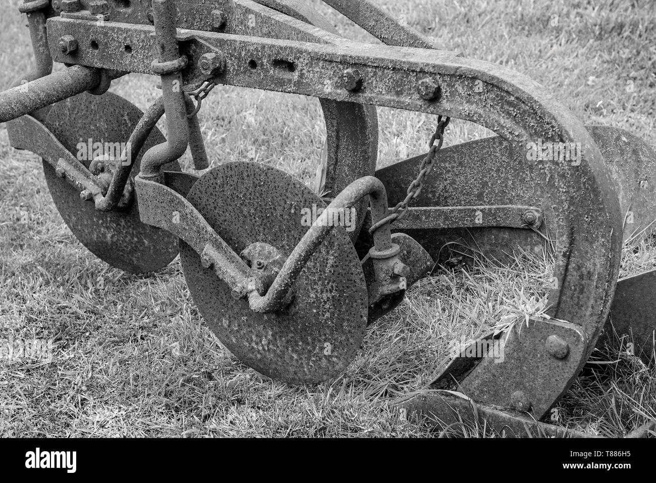 An Old disused plough being used as a garden ornament Stock Photo
