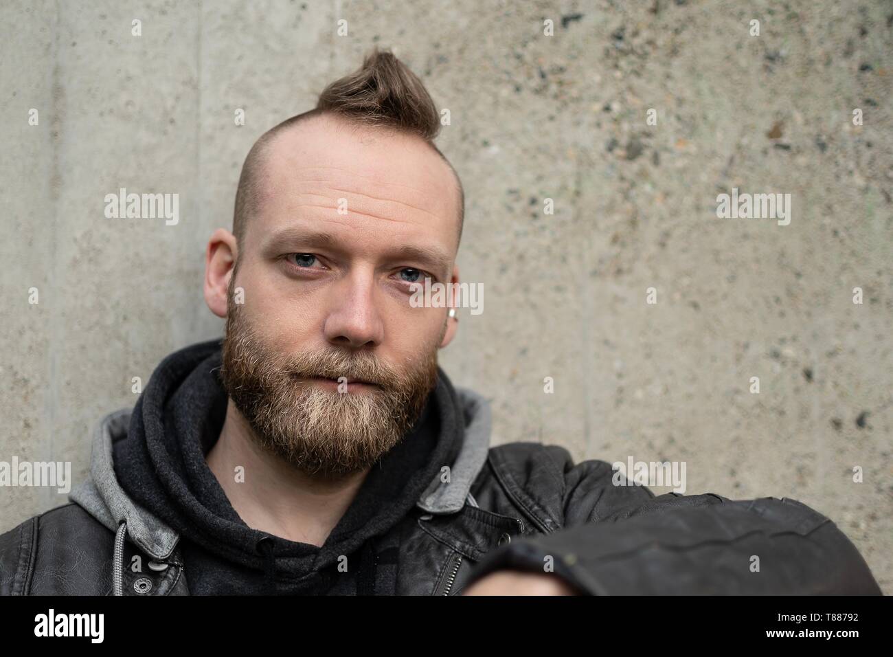 serious or calm young bearded man sitting in front of the camera Stock Photo