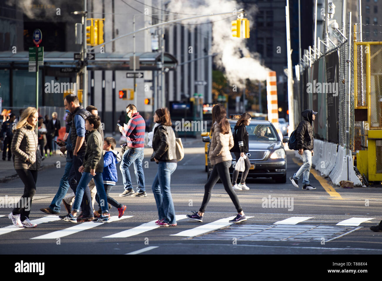 Street traffic on the streets of Manhattan with people crossing a busy road intersection, New York, USA. Stock Photo