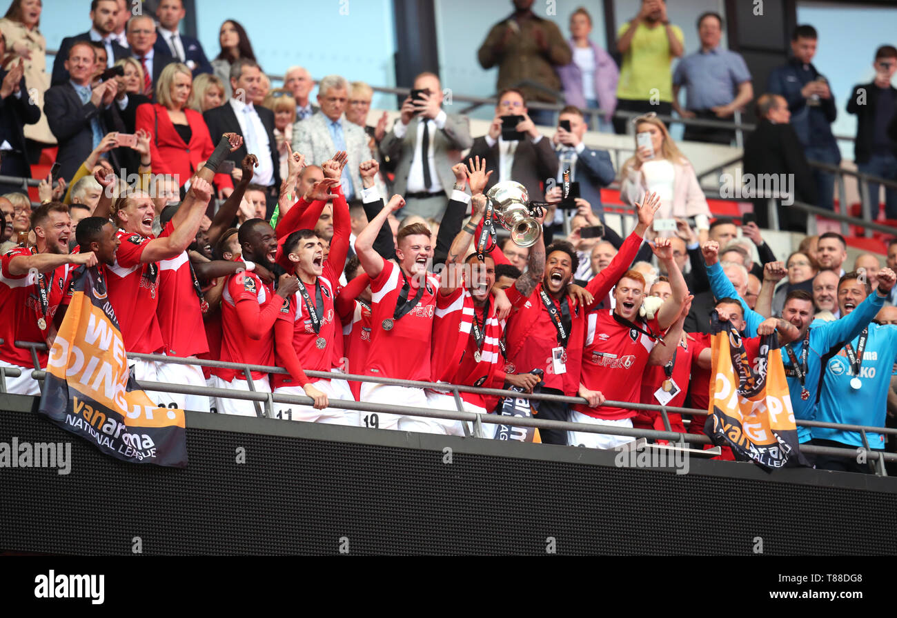 Salford City players celebrate with the trophy after winning the Vanarama National League Play-off Final at Wembley Stadium, London. Stock Photo