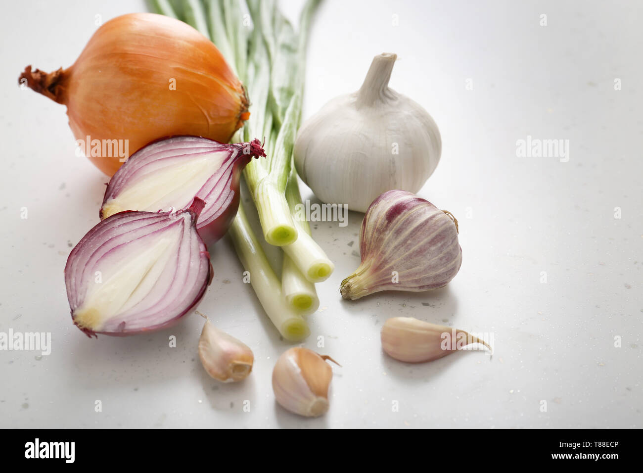 Different fresh onion with garlic on light background Stock Photo Alamy