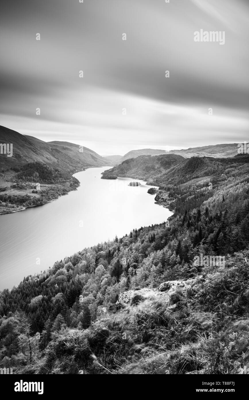 High above Thirlmere reservoir looking down through the autumnal colours in the trees and foliage along the water from Raven Crag. Stock Photo