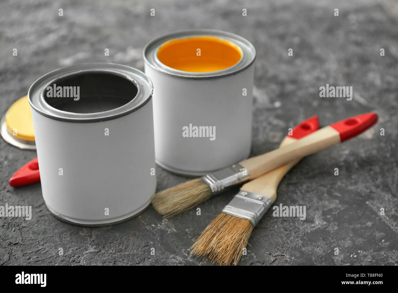 Cans of paint and brushes on grey background Stock Photo