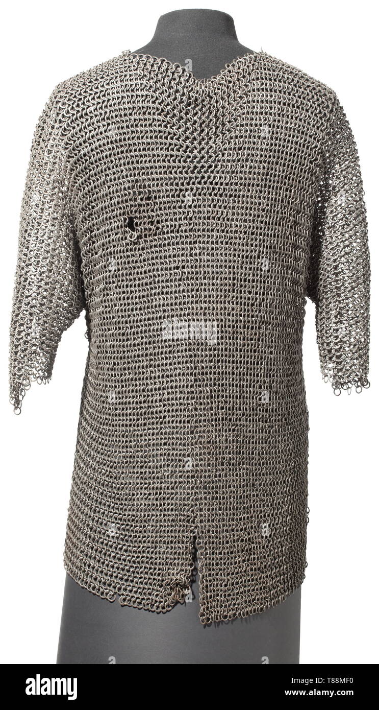 An Ottoman mail shirt, 17th century Constructed of rows of riveted rounded iron rings alternating with rows of slightly larger flattened rings of punched type, the rings of equal gauge throughout, extending over the hips, the neck-opening square-cut and closed by a short overlap, with short arms flared at the openings, and a short V-shaped vent front and rear. Length ca. 76 cm. historic, historical, weapons, arms, weapon, arm, baronial, military, militaria, rapier, rapiers, sword, swords, melee weapon, melee weapons, thrusting, thrustings, baton,, Additional-Rights-Clearance-Info-Not-Available Stock Photo