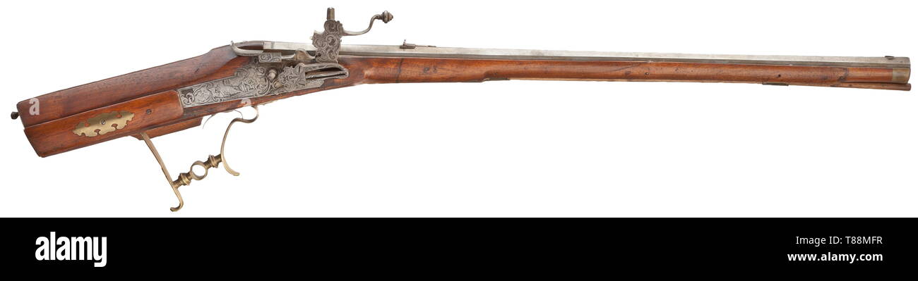 A Bavarian wheellock rifle, Antoni Zurschenthaler, Dingolfing, circa 1720 Slightly swamped, octagonal barrel of earlier date with eight-groove rifled bore in 13 mm calibre with dovetailed sights. At the breech stamped 'MF' and dated '1681'. (Replaced) wheellock chiselled with tendrils and figures and internal wheel, the lockplate with signature 'ANT. ZURSCHENTHALLER'. Defective double set trigger. Smooth walnut full stock with horn nose and patchbox. The trigger guard is a non-matching replacement, later wooden ramrod. The stock with lining near , Additional-Rights-Clearance-Info-Not-Available Stock Photo