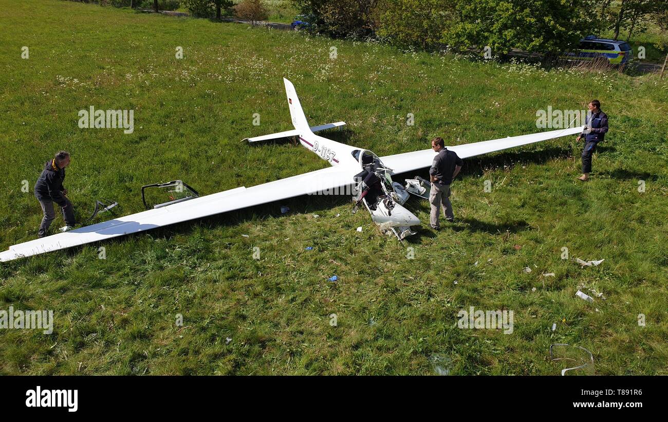 11 May 2019, Germany (German), Rhede: A policeman (M) and two men stand next to a crashed glider. The 29-year-old pilot was fatally injured in the crash. The woman took an exam for artificial glider pilots when she lost control of the plane, the police said. Photo: -/NWM/dpa Stock Photo