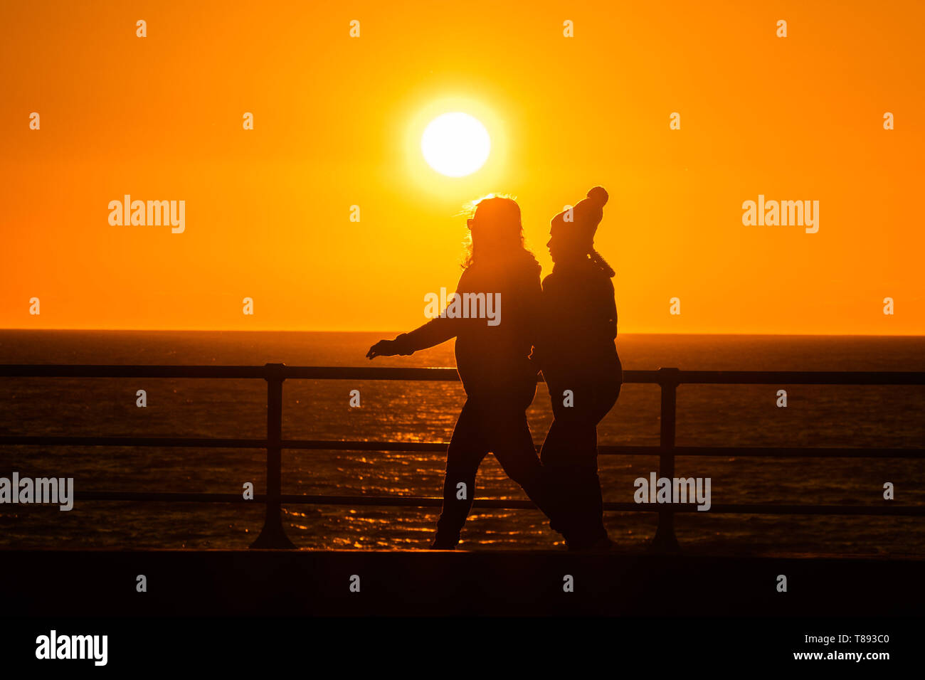 Aberystwyth Wales UK, Saturday 11 May 2019  UK Weather: People are silhouetted  against the glorious setting sun as they XXXXXX in Aberystwyth on the Cardigan Bay coast, West Wales. The weather is set to get warmer again in the coming week after as period of unsettled cold conditions.   photo credit Keith Morris / Alamy Live News Stock Photo