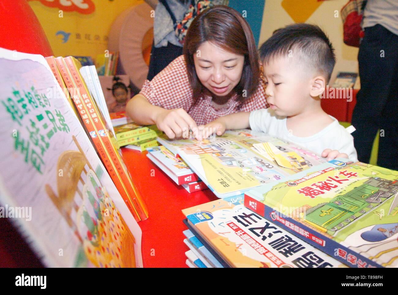 Beijing, China. 12th May, 2019. A boy reads a book with his mother in Beijing, capital of China
