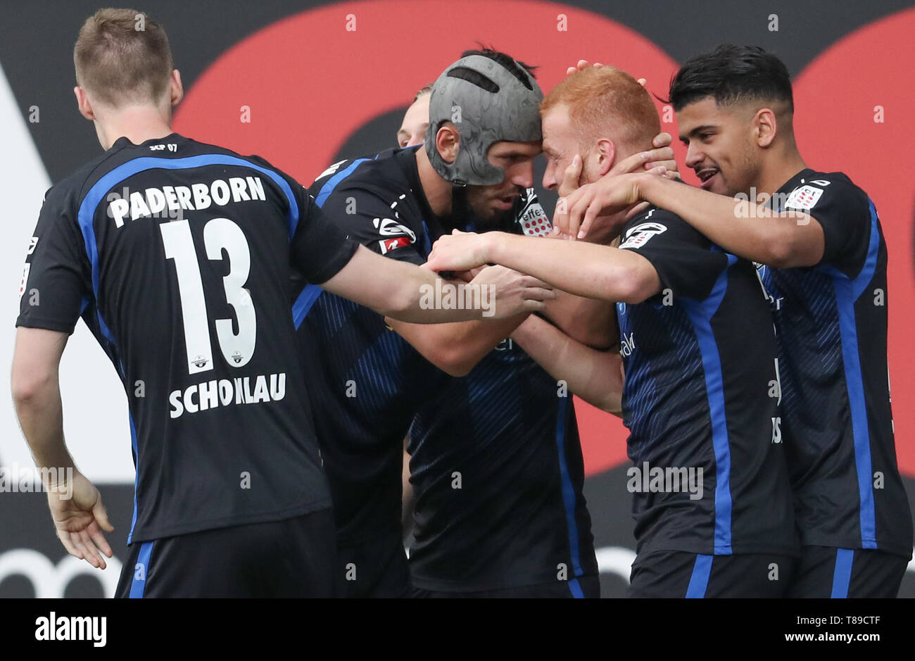 Paderborn, Germany. 12th May, 2019. Soccer: 2nd Bundesliga, SC Paderborn 07 - Hamburger SV, 33rd matchday in the Benteler Arena. Paderborn's scorer Sebastian Vasiliadis (2nd from right) celebrates his 2-0 goal with Sebastian Schonlau (l-r), Klaus Gjasula and Mohamed Dräger. Credit: Friso Gentsch/dpa - IMPORTANT NOTE: In accordance with the requirements of the DFL Deutsche Fußball Liga or the DFB Deutscher Fußball-Bund, it is prohibited to use or have used photographs taken in the stadium and/or the match in the form of sequence images and/or video-like photo sequences./dpa/Alamy Live News Stock Photo