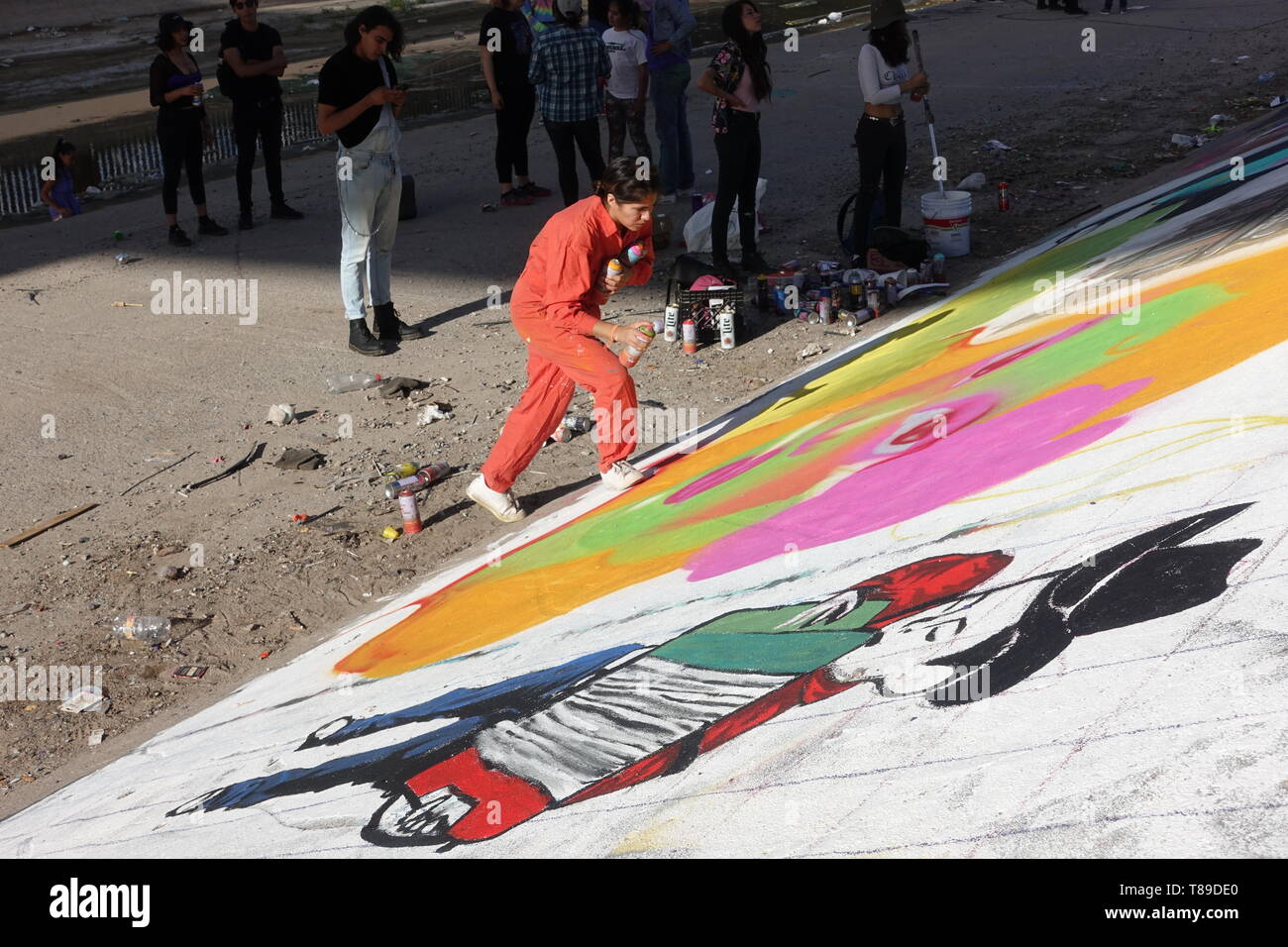 Ciudad Juarez, Mexico. 14th Jan, 2016. The Mexican artist Lupita Pinta is working on an image of a child in the canal of the Rio Bravo border river. A cross-border graffiti meeting with artists from both countries took place in the canal. Credit: David Peinado/dpa/Alamy Live News Stock Photo