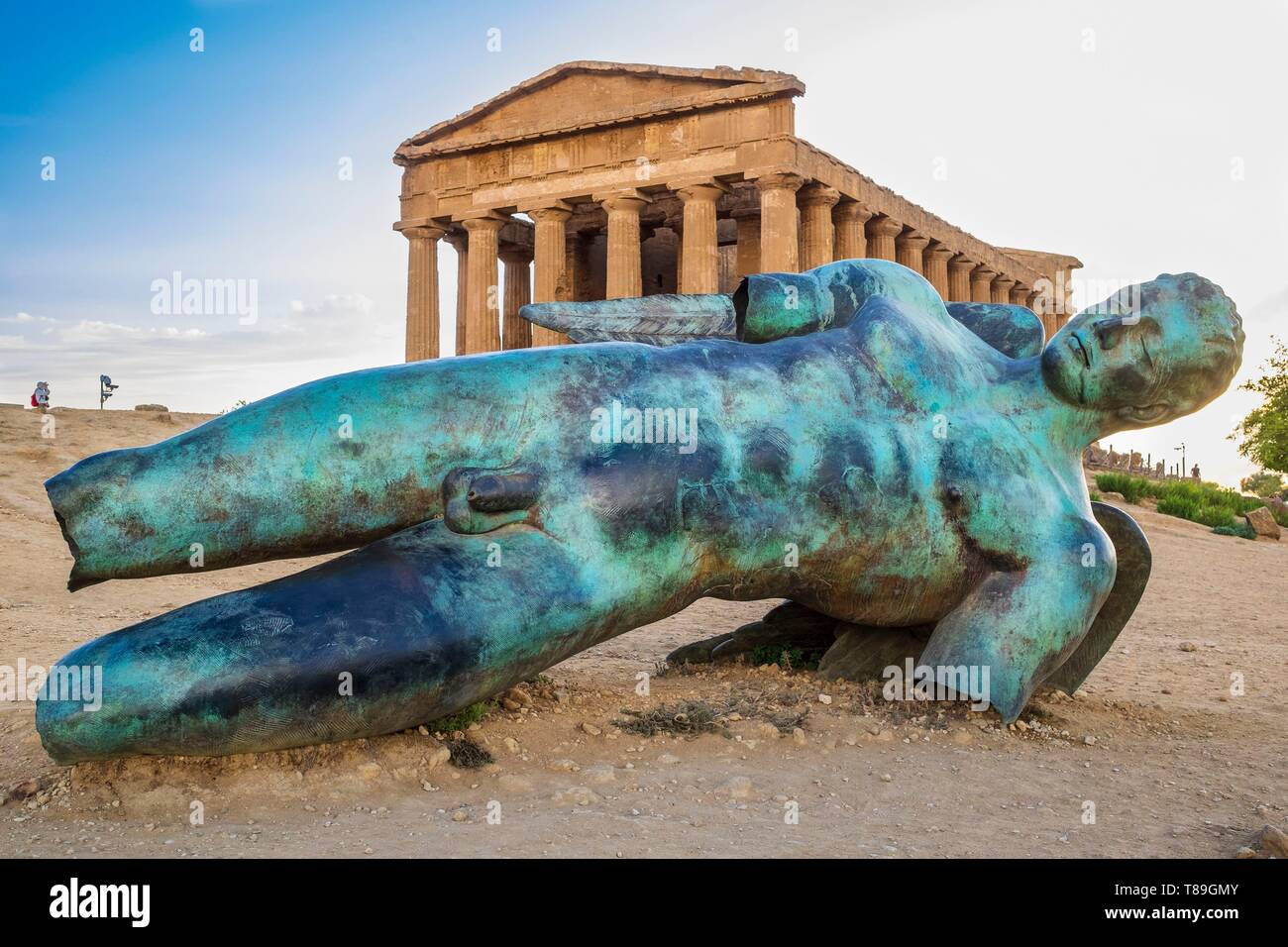 Italy, Sicily, Agrigento, Valley of the Temples, UNESCO World Heritage site, temple of Concordia and bronze statue Fallen Icare by the french-polish sculptor Igor Mitoraj Stock Photo