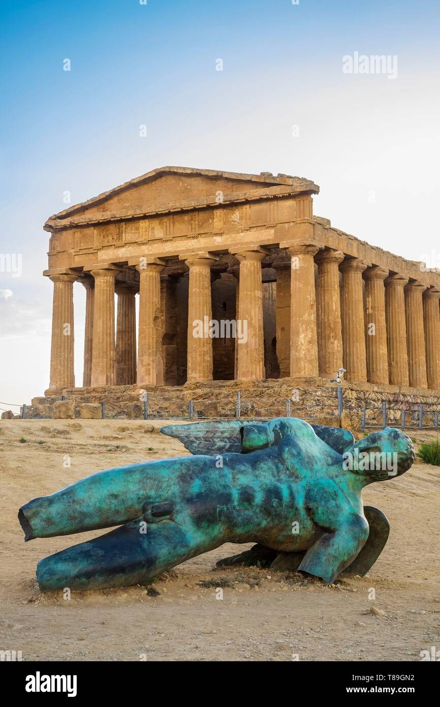 Italy, Sicily, Agrigento, Valley of the Temples, UNESCO World Heritage site, temple of Concordia and bronze statue Fallen Icare by the french-polish sculptor Igor Mitoraj Stock Photo