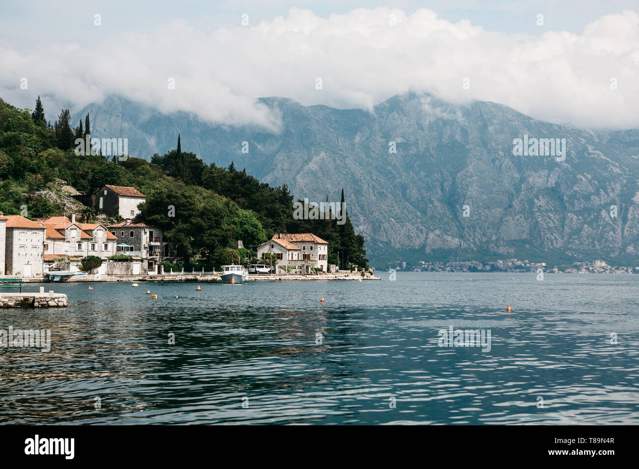 Beautiful view of the coastal old town of Perast in Montenegro against the backdrop of the mountains. Natural landscape. Stock Photo