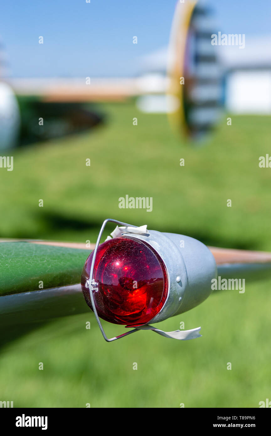 Red vintage left side aviation navigation light bulb in clip on end of