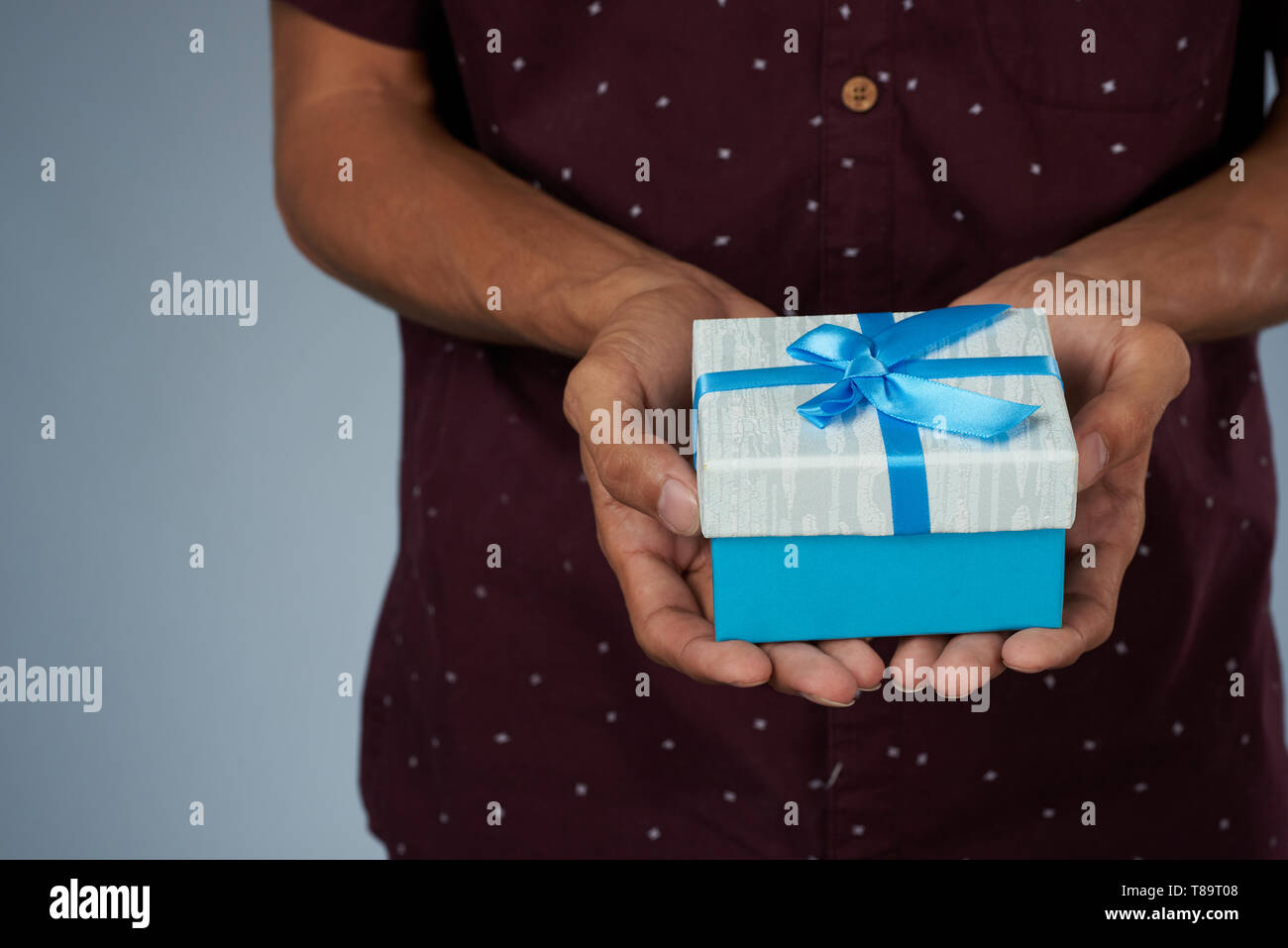 Blue gift box on man hands close up view Stock Photo