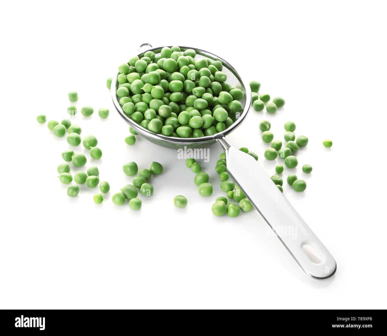 Sieve with green peas on white background Stock Photo