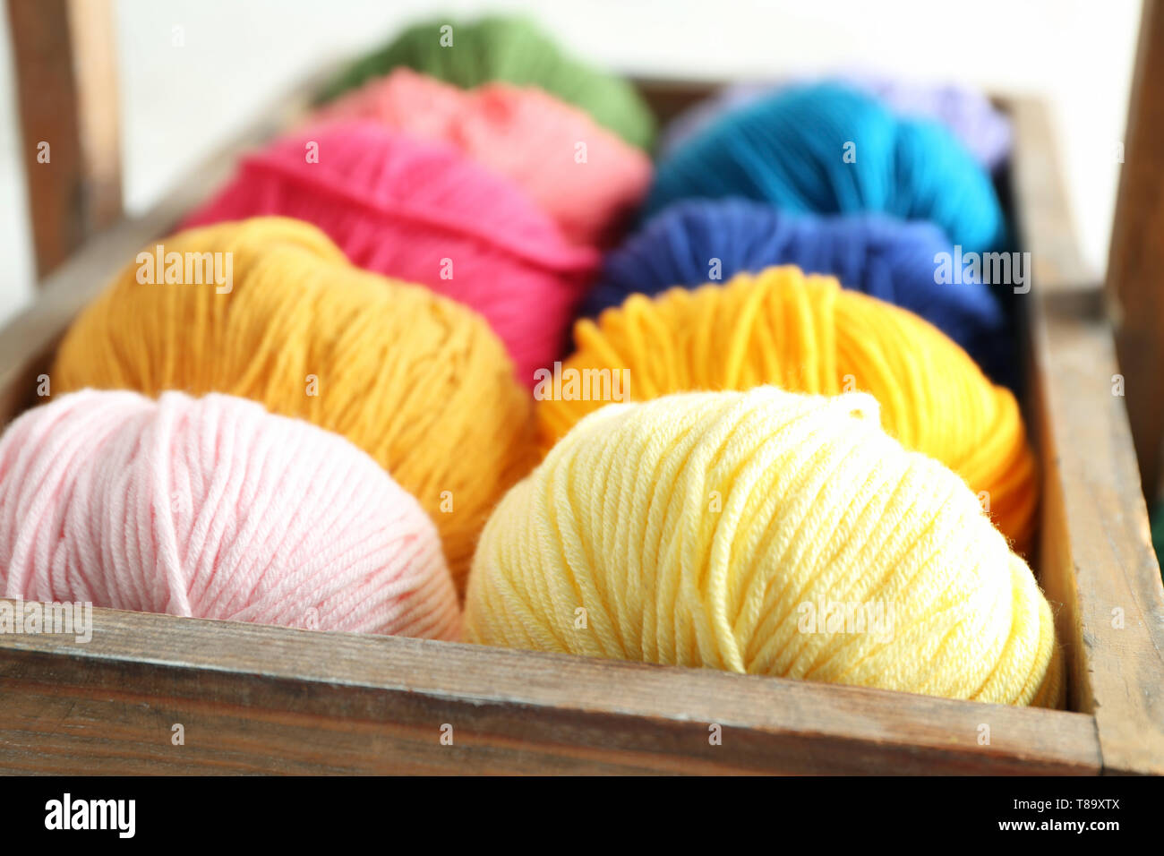 Wooden basket with balls of knitting yarn, closeup Stock Photo - Alamy