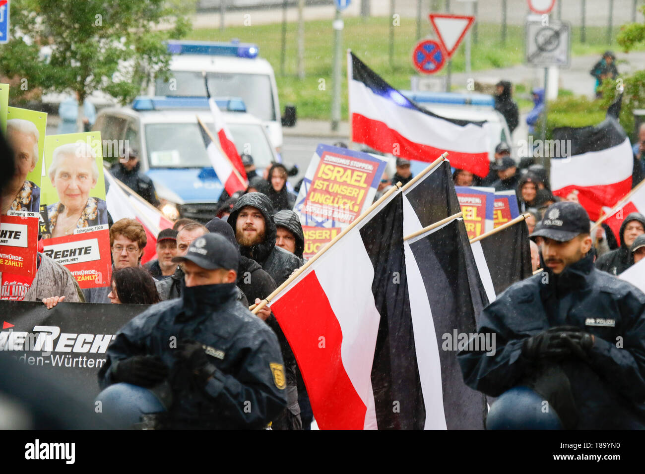 Pforzheim, Germany. 11th May 2019. The right-wing protesters march with banners, posters and flags of the German Empire through the city centre in the pouring rain. Around 80 people participated in a march through Pforzheim, organised by the right-wing party ‘Die Rechte’ (The Right). The main issues of the march was the promotion of voting for Die Rechte’ in the upcoming European Election and their anti-immigration policies. They were confronted by several hundred counter-protesters from different political organisations. Stock Photo