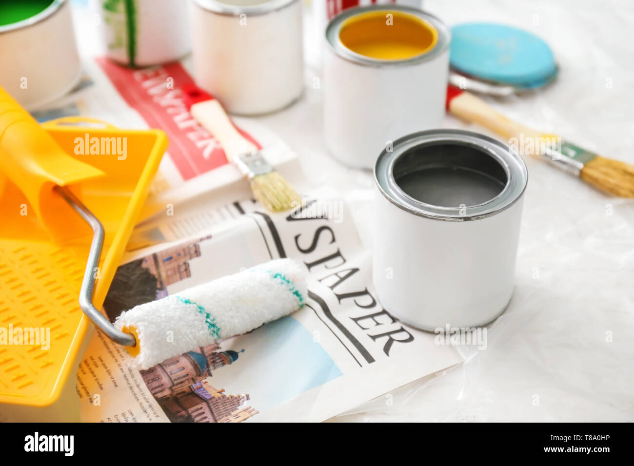 Paint cans with tools on table Stock Photo