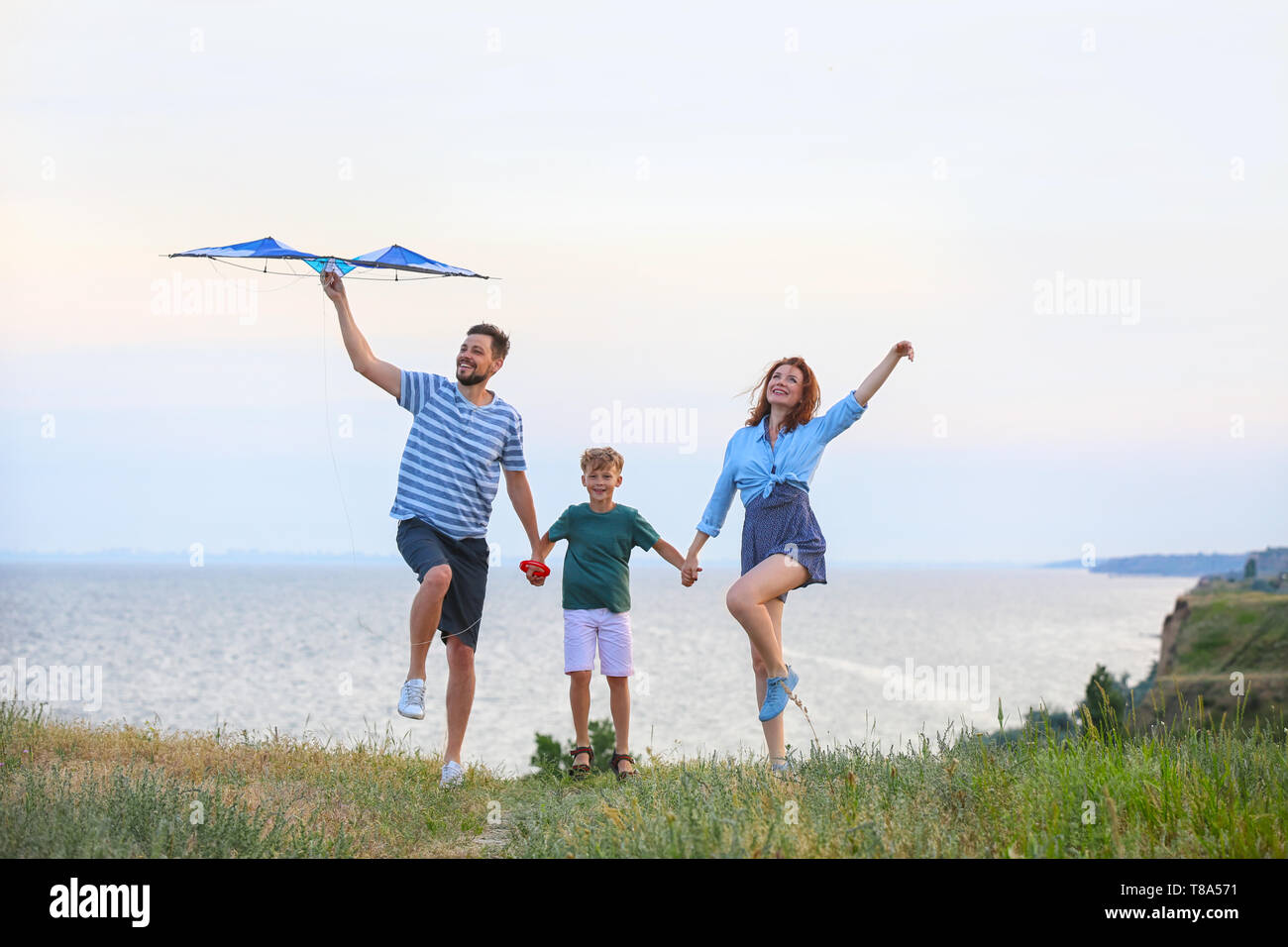 Happy family flying kite near sea Stock Photo - Alamy