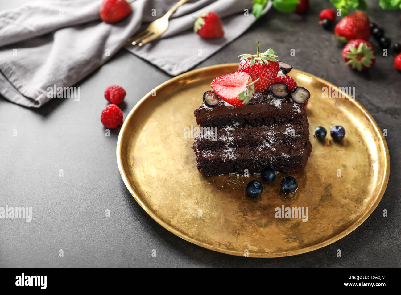 Piece of delicious chocolate cake with berries on metal tray Stock ...