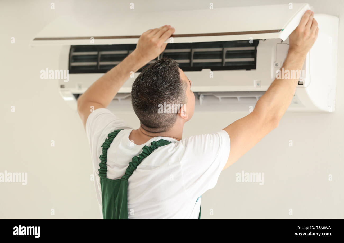 Electrician repairing air conditioner indoors Stock Photo Alamy