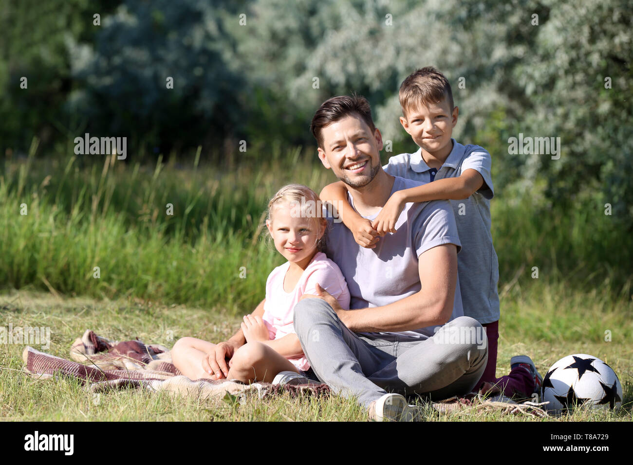 Man with his little children resting in park Stock Photo